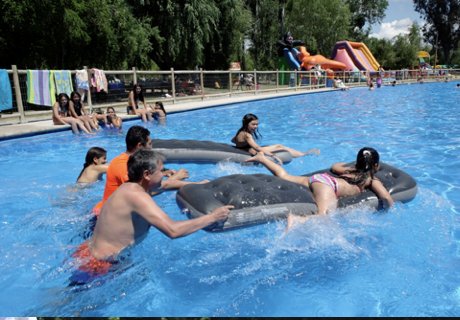 Ninos jugando en la piscina con inflables